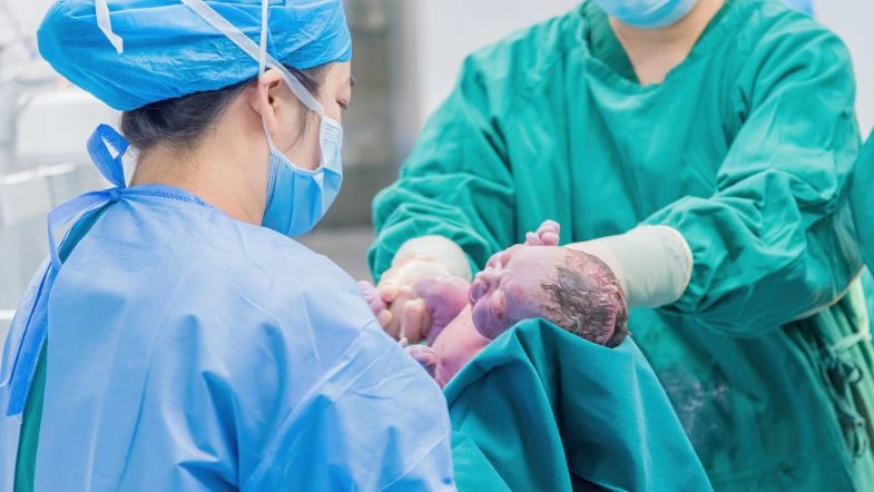 Enfermagem Obstétrica: o enfermeiro e a humanização do parto 7 Equipe de profissionais da saúde realiza o parto de um bebê em ambiente hospitalar, simbolizando a atuação da Enfermagem Obstétrica com foco na segurança e humanização do nascimento.