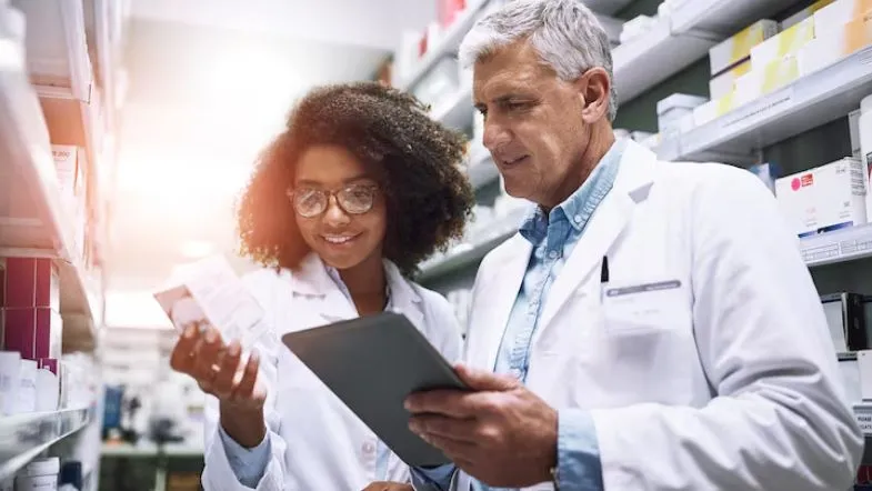 Pós-Graduação em Farmácia Clínica e Atenção Farmacêutica: transforme sua prática profissional 6 Farmacêuticos analisando medicamentos com tablet em farmácia, simbolizando atuação clínica e tomada de decisão baseada em evidências.