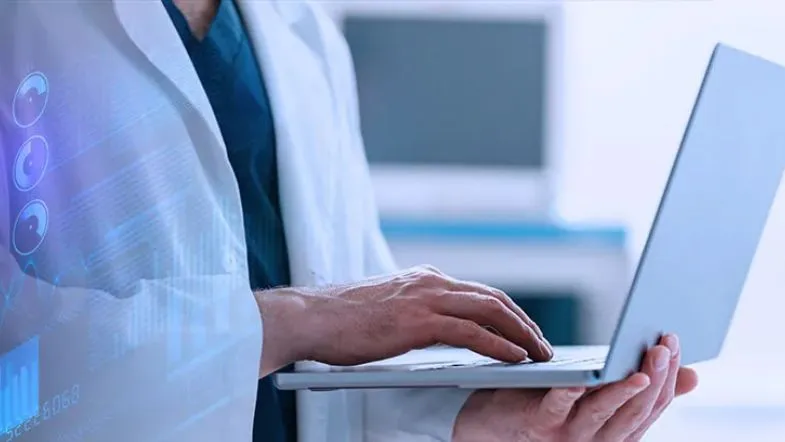 ITH Notícias: os principais destaques do evento “O Novo Jogo do Marketing Digital na Saúde” 6 Profissional da saúde manuseando notebook com gráficos digitais projetados, representando tecnologia e análise de dados clínicos.