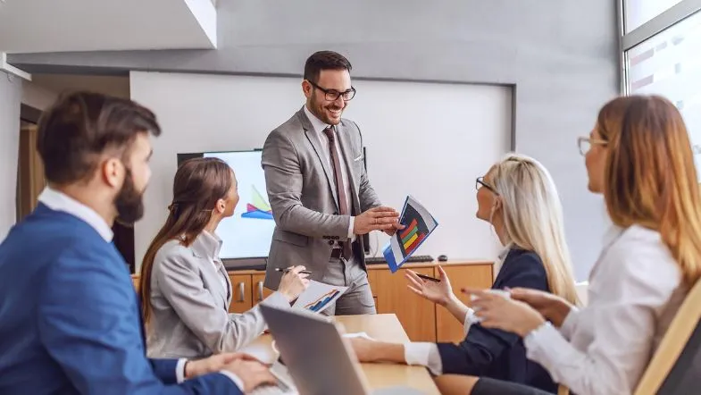 Alta Performance: desenvolva seu potencial e supere seus limites 6 Profissional apresentando dados em reunião corporativa, simbolizando liderança, desempenho e trabalho em equipe com foco em alta performance.