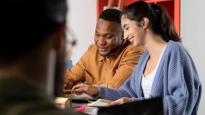 FIES 2025: como financiar sua faculdade com segurança 8 Dois estudantes, homem e mulher, trabalham juntos em atividades acadêmicas com expressão de satisfação e colaboração.