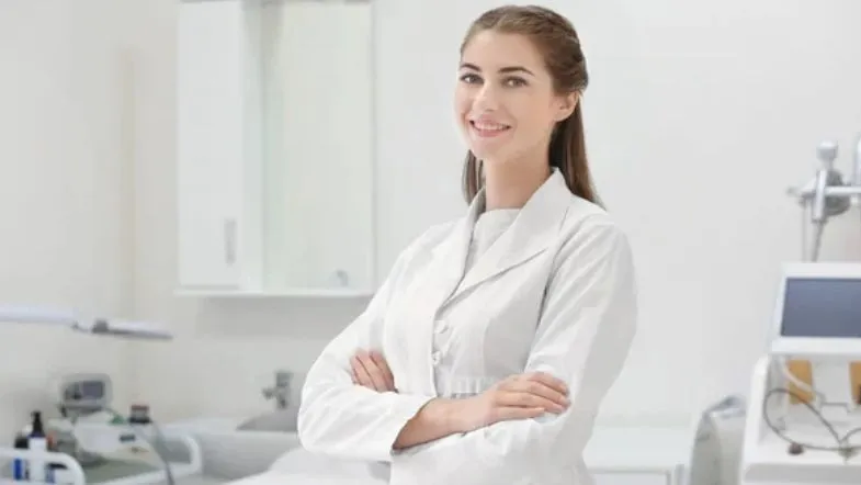 Estética avançada pode aplicar Botox? Saiba quem está autorizado no Brasil 8 Profissional da estética ou da saúde posando em consultório com jaleco branco, simbolizando autoridade, confiança e qualificação na área estética.