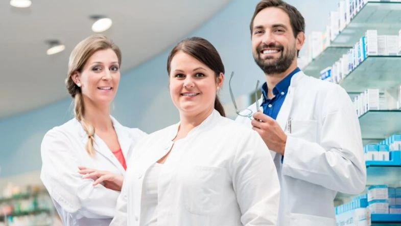 Fitoterapia e Fitomedicamentos: aula magna marca lançamento de Pós em Farmácia Clínica 9 Três farmacêuticos sorrindo em ambiente clínico, simbolizando atuação em Farmácia Clínica e atenção farmacêutica.