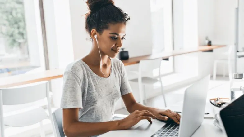 Ensino EAD: saiba quais cursos não podem ser 100% a distância segundo o MEC 6 Jovem estudante utilizando fones de ouvido enquanto assiste aula EAD em um notebook em ambiente iluminado e moderno.