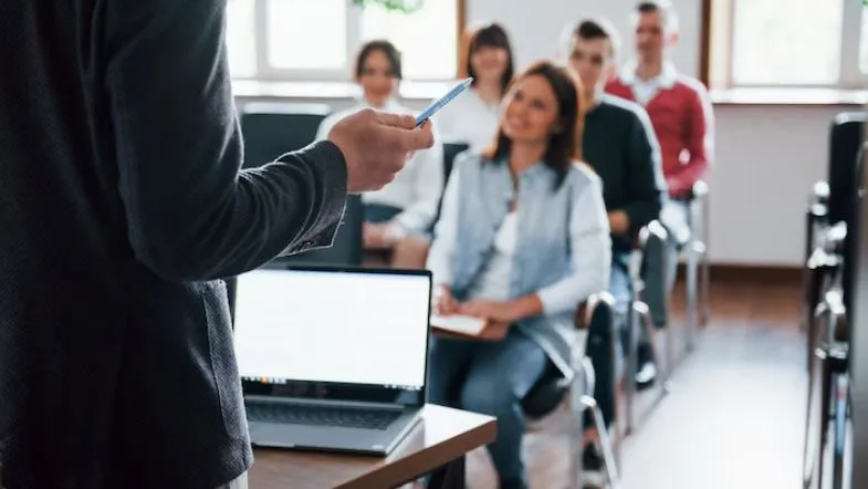 Curso híbrido ou EAD? Veja as diferenças e qual é melhor para você 7 Professor conduz aula presencial com alunos atentos, reforçando a importância da vivência prática.