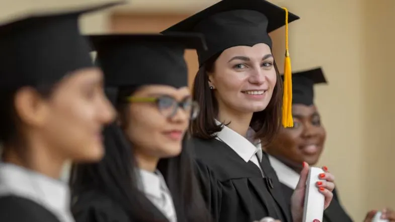 Ensino superior em 2025: saiba como ingressar na faculdade com segurança 9 Alunas em cerimônia de formatura com beca e diploma na mão, simbolizando a conquista do ensino superior.