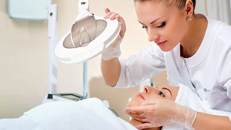 Avaliação facial detalhada com lupa durante consulta estética especializada.