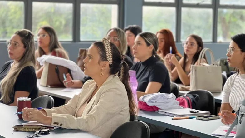 Educação de verdade: como a Faculdade ITH se prepara para os próximos 10 anos 6 Alunos da Faculdade ITH atentos assistindo a uma aula em sala, com cadernos, laptops e garrafas de água sobre as mesas.