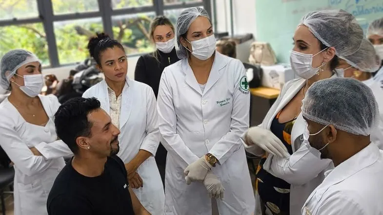 ITH 10 anos: da inovação à liderança no ensino superior brasileiro 7 Alunos da área da saúde e estética da Faculdade ITH em aula prática supervisionada, usando jalecos e equipamentos de proteção individual.