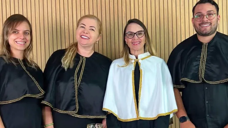 ITH 10 anos: da inovação à liderança no ensino superior brasileiro 8 Equipe da Faculdade ITH sorrindo durante evento acadêmico, usando vestes formais de cerimônia de colação de grau ou formatura.