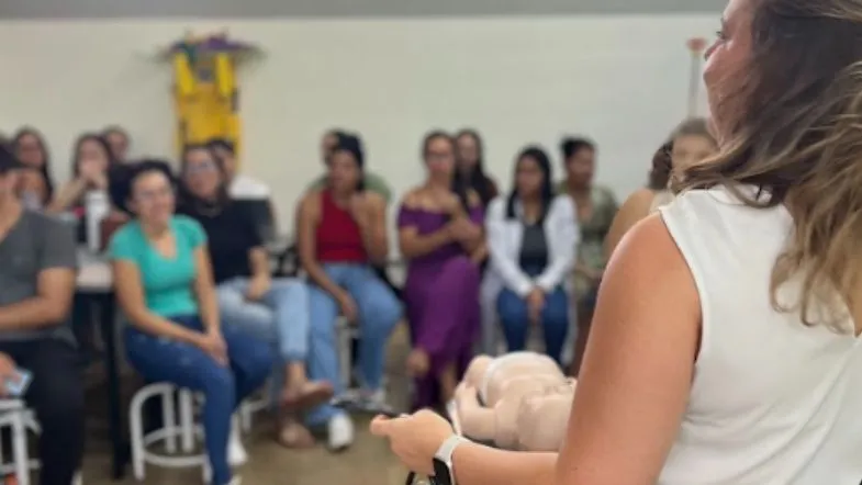 Educação de verdade: como a Faculdade ITH se prepara para os próximos 10 anos 8 Instrutora apresentando conteúdo prático para uma turma, com alunos observando atentamente em um ambiente de aula prática.