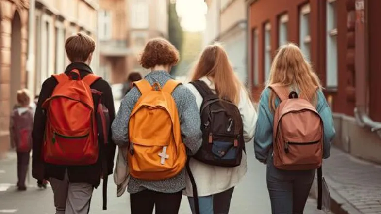 Como se preparar para o ENEM 2025 e conquistar sua vaga na faculdade 8 Quatro estudantes com mochilas caminhando juntos para a escola.