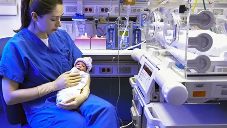 Pós em UTI Neonatal e Pediátrica: o passo decisivo para sua carreira na saúde 9 Enfermeira oferece acolhimento a recém-nascido em ambiente de alta complexidade, reforçando o papel do cuidado humanizado na terapia intensiva pediátrica.