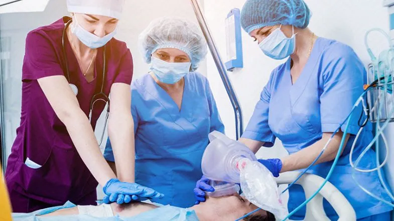Especialização Técnica em Urgência e Emergência: vale a pena investir nesse curso? 6 Equipe de enfermagem realizando massagem cardíaca e ventilação em paciente em parada cardiorrespiratória, prática do curso de urgência e emergência.
