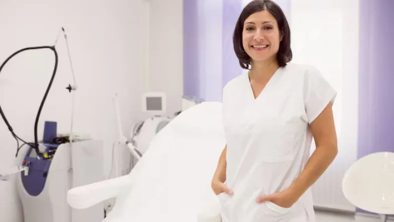 Estética Avançada: como o Ultraformer MPT pode transformar sua carreira 10 Esteticista sorridente em consultório moderno preparado para procedimentos com tecnologias de estética avançada.