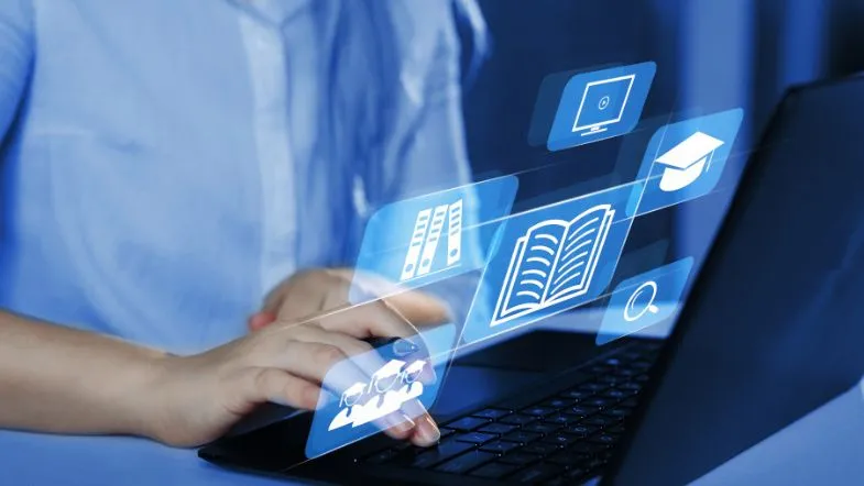 Edtech em Saúde: como o lifelong learning está transformando carreiras na saúde 10 Pessoa usando notebook com ícones digitais flutuantes representando livros, diplomas e arquivos, ilustrando o uso de tecnologias edtech no ensino em saúde.
