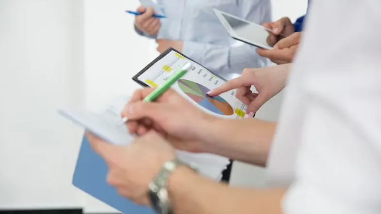 Gestores analisando gráficos e relatórios em reunião, com foco em indicadores de desempenho hospitalar.