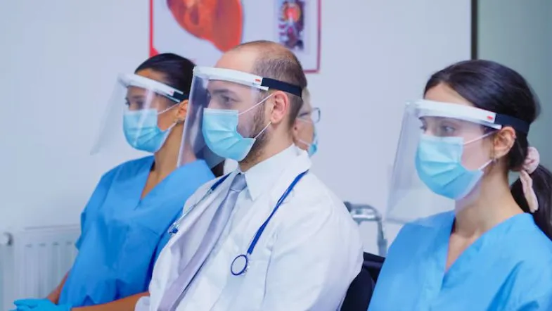Segurança do paciente: como reduzir eventos adversos com protocolos simples 11 Profissionais de saúde usando protetor facial durante capacitação ou treinamento clínico.