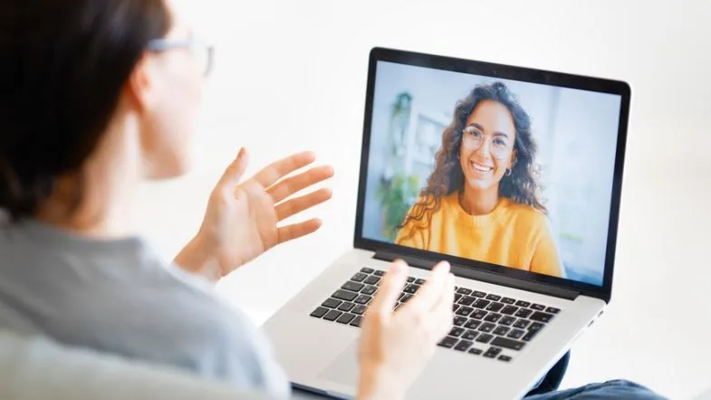 Atendente em videoconferência sorridente, simbolizando atuação em psicologia online e teleatendimento.