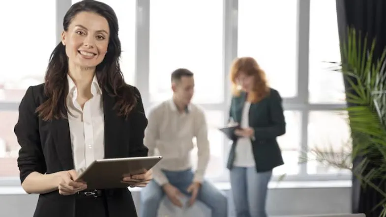Graduação em Administração: salário, funções, oportunidades e áreas de atuação 13 Profissional de Administração com tablet; liderança feminina e empregabilidade em diferentes setores.