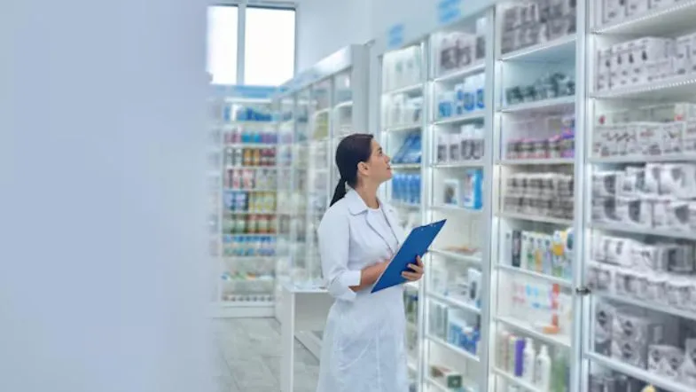 Pós-Graduação em Farmácia: veja qual área combina com o seu perfil profissional 6 Profissional farmacêutica avaliando prateleiras de medicamentos em farmácia hospitalar, aplicando práticas aprendidas em pós-graduação em Farmácia.