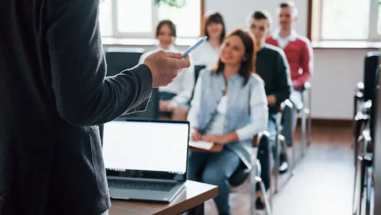 10 pós-graduações com alta empregabilidade em 2025: veja o ranking completo 6 Professor ministrando aula para turma de estudantes adultos em ambiente acadêmico.