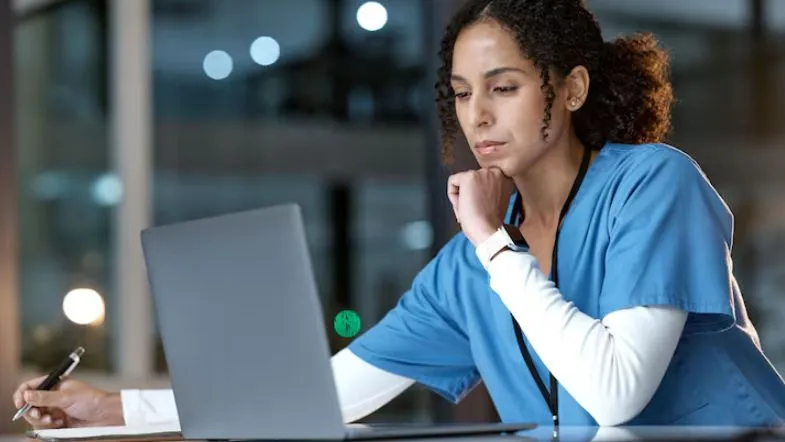 Auditoria, acreditação e compliance na saúde: os novos pilares da saúde em 2025 6 Enfermeira realiza auditoria clínica em laptop, verificando indicadores de qualidade assistencial e conformidade hospitalar.