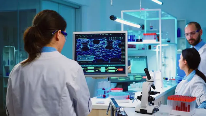 Profissões do futuro na saúde: o que o mercado vai exigir até 2030 6 Profissionais da área da saúde analisando dados clínicos em laboratório com tecnologia avançada e biotecnologia.