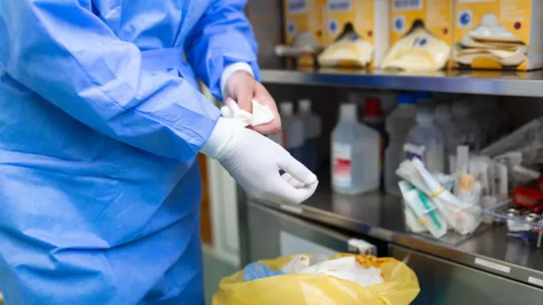 Profissional da saúde realizando descarte correto de resíduos hospitalares conforme normas ambientais e sanitárias.