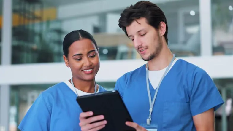 Profissionais da saúde analisando dados em tablet, simbolizando saúde digital e inovação tecnológica.