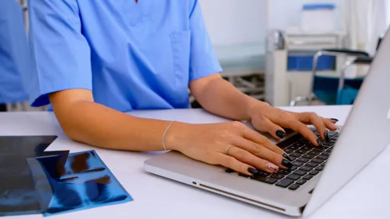 Profissões do futuro na saúde: o que o mercado vai exigir até 2030 7 Profissional da saúde utilizando notebook para análise de dados clínicos e gestão hospitalar digital.
