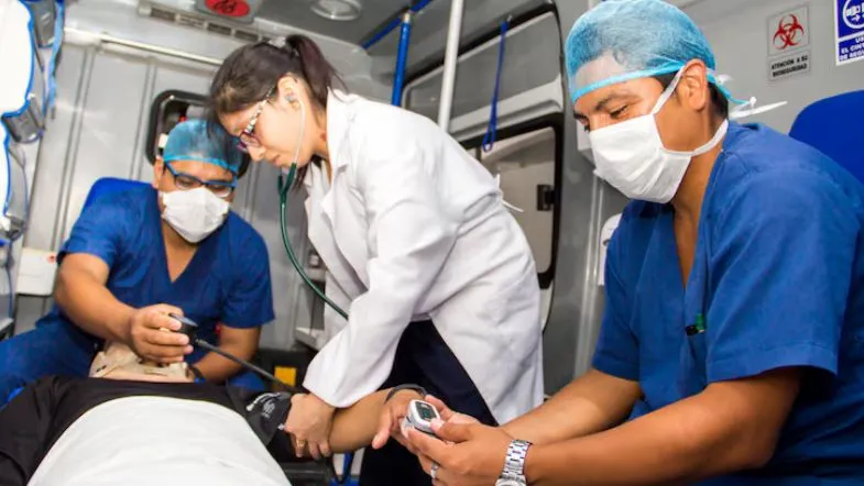 Especialização na área da saúde: conheça 6 caminhos de sucesso profissional 8 Profissionais de saúde realizando atendimento pré-hospitalar em ambulância, simbolizando a especialização em Urgência e Emergência / APH.