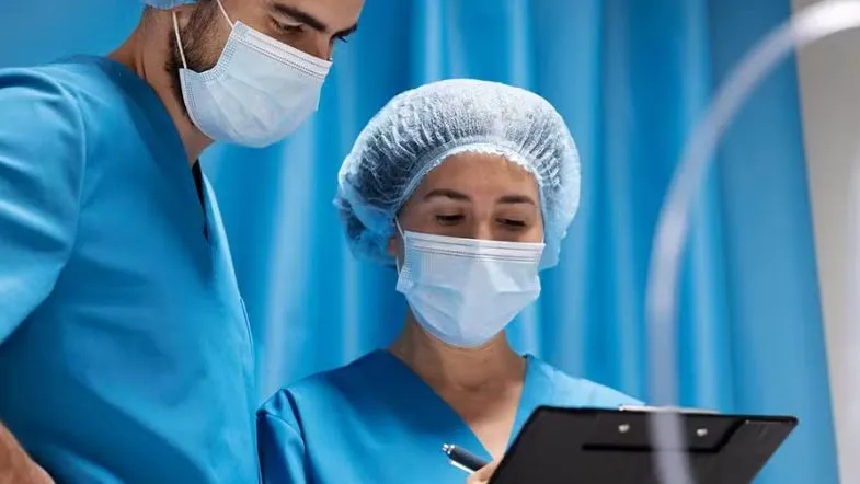 Equipe de fisioterapeutas analisa prontuário de paciente em unidade hospitalar.
