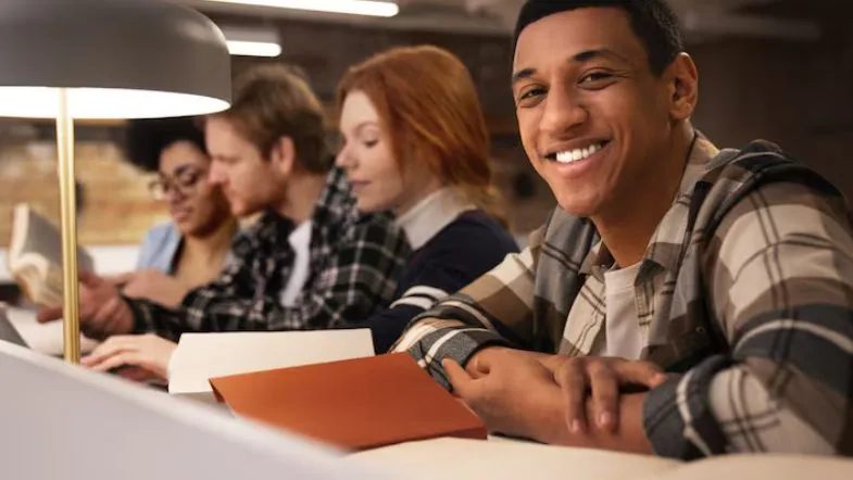 Grupo de estudantes estudando em conjunto em uma biblioteca, reforçando técnicas colaborativas de estudo para o ENEM 2025.