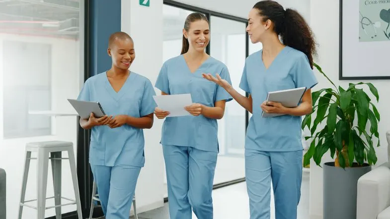 Como a saúde mental vai redefinir a gestão hospitalar nos próximos anos 8 Grupo de profissionais caminhando e conversando em hospital, demonstrando integração e trabalho em equipe na gestão hospitalar.