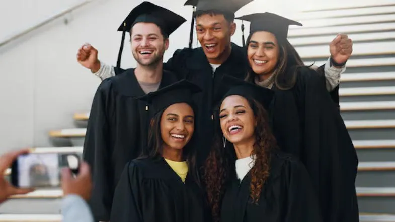 Como escolher a graduação certa: 7 passos para evitar frustrações 9 Grupo de formandos com beca celebra a conquista do diploma de graduação com alegria e união.