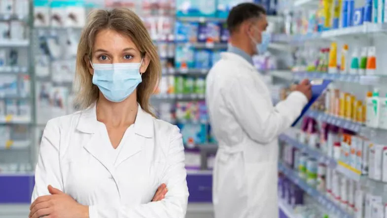 Pós-Graduação em Farmácia: veja qual área combina com o seu perfil profissional 9 Farmacêutica com máscara e jaleco em ambiente clínico, simbolizando a valorização da carreira com pós-graduação em Farmácia pela Faculdade ITH.