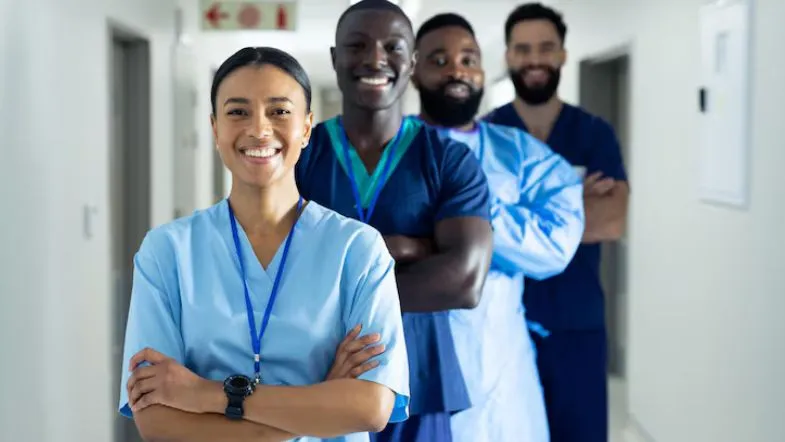 Equipe de enfermeiros e profissionais de saúde sorrindo em ambiente hospitalar.