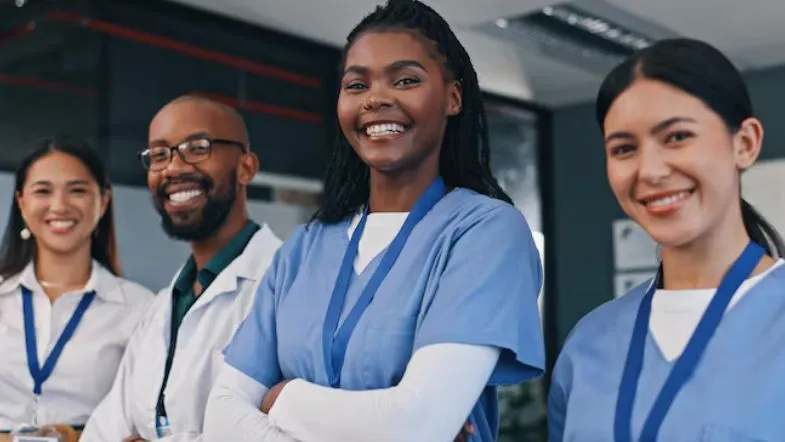 Gestão sob pressão: estratégias para formar times de alta performance 9 Equipe de profissionais da saúde sorrindo e confiante, simbolizando liderança eficaz e gestão de alto desempenho.