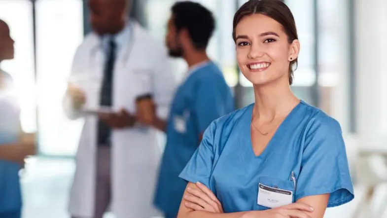 Profissional da saúde sorridente em hospital, transmitindo segurança e empregabilidade conquistadas pela especialização.