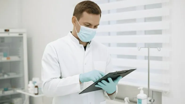 Farmácia Clínica em 2025: a regulamentação que ampliou o protagonismo do farmacêutico 6 Profissional da saúde utilizando prancheta para registrar informações clínicas em um consultório farmacêutico.