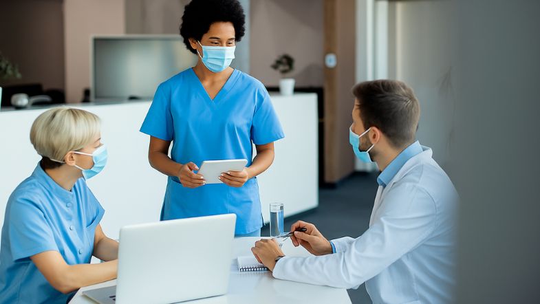 Gestão Hospitalar em 2025: como reduzir custos sem perder qualidade 6 Gestores hospitalares e enfermeiros utilizando tecnologia digital em reunião para otimizar a qualidade assistencial.