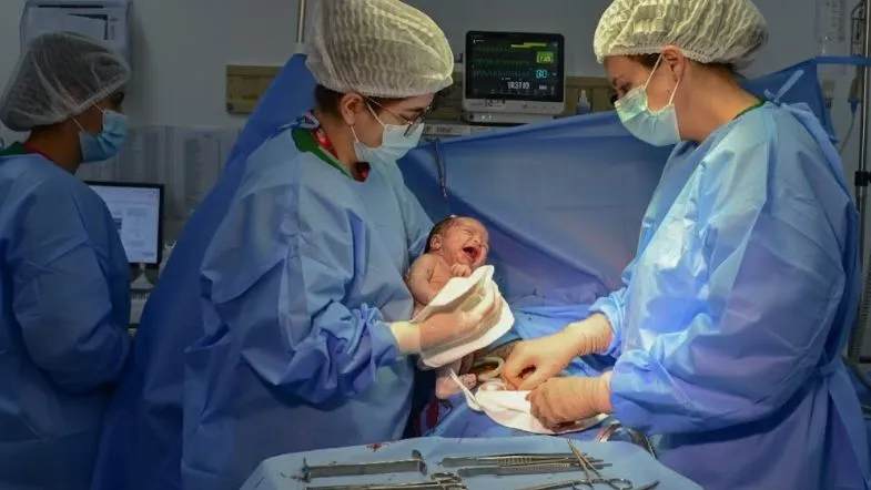 Obstetrícia na prática: como a pós-graduação presencial forma especialistas 7 Equipe obstétrica realizando assistência ao recém-nascido logo após o nascimento em centro cirúrgico.