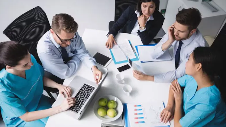 Gestão além das empresas: 7 áreas para crescer na carreira em 2025 8 Reunião de profissionais da saúde e gestores discutindo estratégia e indicadores em um hospital