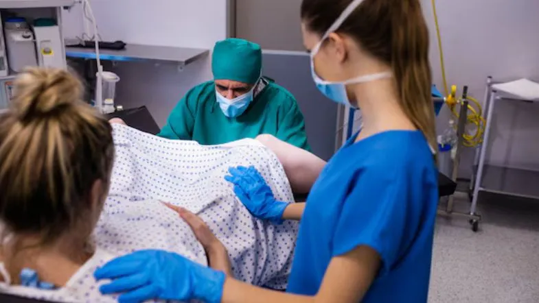 Enfermeira obstetra e equipe médica realizando parto humanizado em hospital, priorizando conforto e segurança da mulher.