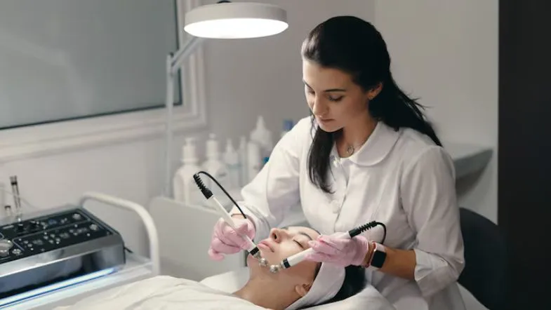 Profissional realizando procedimento facial estético com equipamento de radiofrequência