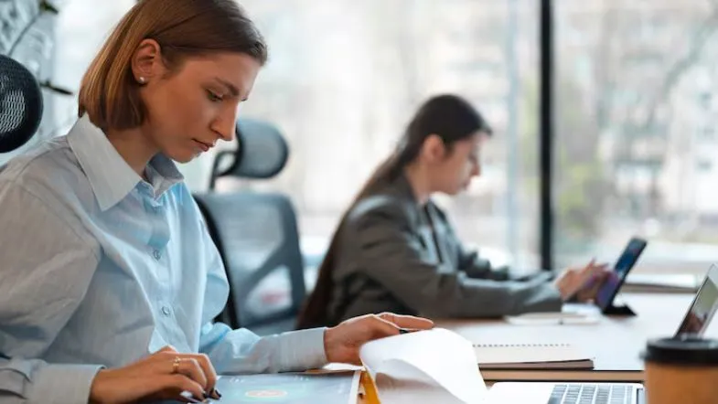 Gestão além das empresas: 7 áreas para crescer na carreira em 2025 9 Jovem profissional analisando relatórios e desenvolvendo planejamento em escritório.