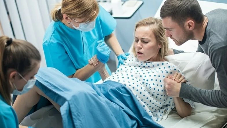 Parto baseado em evidências: o que muda para a enfermagem obstétrica em 2026 7 Equipe de enfermagem obstétrica apoiando parturiente durante o trabalho de parto, com acompanhante ao lado.