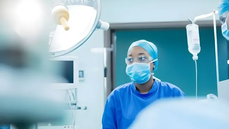 O futuro da emergência hospitalar: o que muda em 2026 e qual formação será obrigatória 7 Enfermeira utilizando máscara cirúrgica em ambiente de cirurgia e assistência crítica.