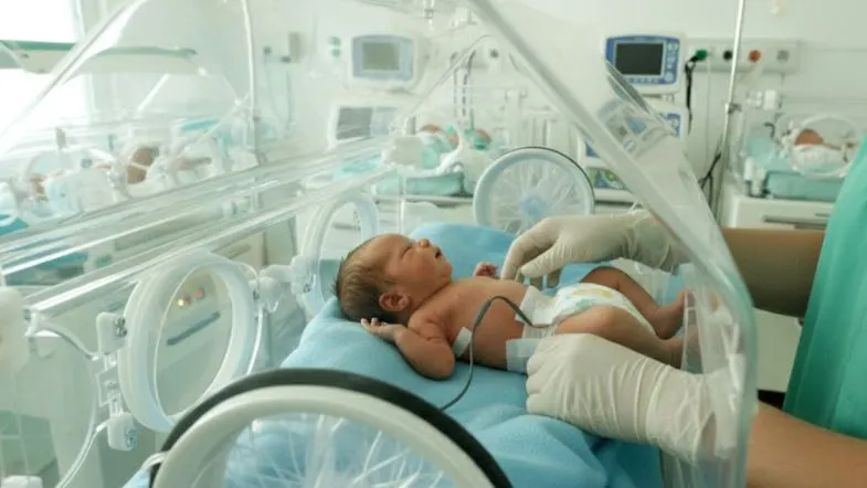 Recém-nascido prematuro em incubadora neonatal com monitorização clínica e assistência especializada em UTI Neonatal.